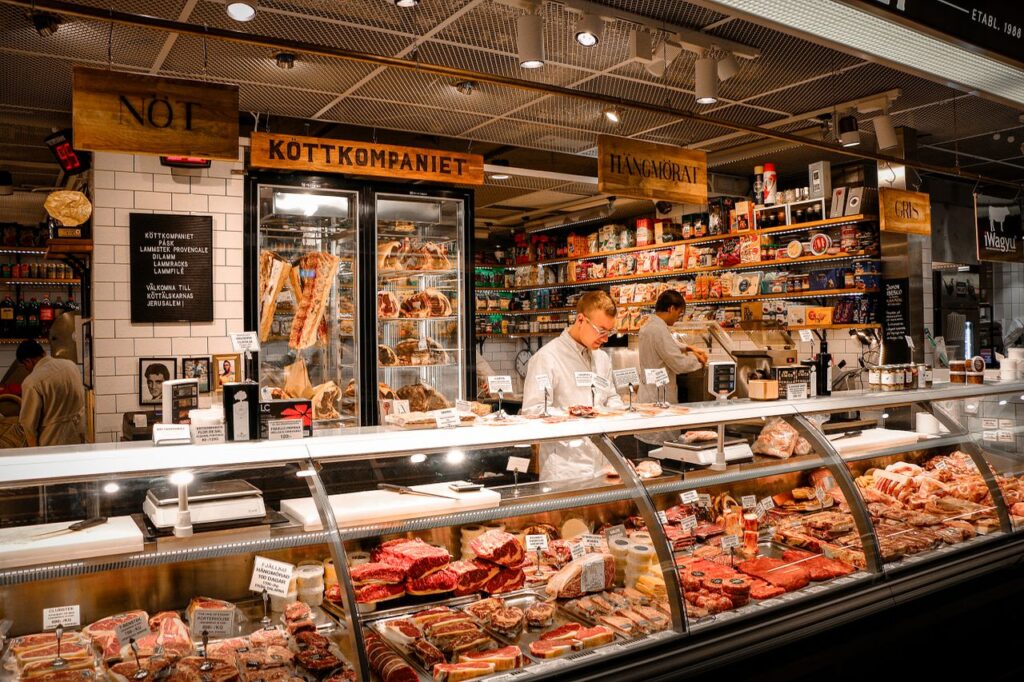 A vibrant butcher shop counter in Stockholm, Sweden, featuring various fresh meats and products.